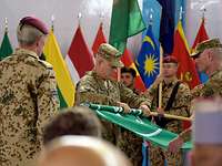 Ein US-amerikanischer Soldat rollt bei einer Zeremonie die ISAF-Flagge ein