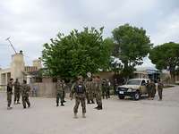 Mehrere afghanische Soldaten sichern die Straße vor einem Militärgelände