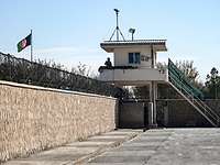 Ein Wachturm an einer Mauer mit afghanischer Flagge