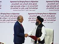 Zalmay Khalilzad und Mullah Abdul Ghani Baradar geben sich die Hand