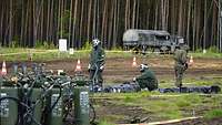 Soldaten in ABC-Schutzbekleidung warten auf ihren Einsatz zur Dekontamination