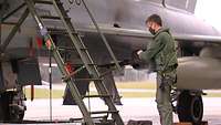 Ein Pilot steht vor einer Treppe vor einem Eurofighter, um in das Cockpit zu gelangen.
