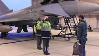 Ein Techniker grüßt militärisch einen Piloten und meldet ihm den Status eines Eurofighters.