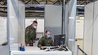 Zwei Kameraden sitzen in einer Registrierungsbox