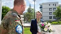 Hauptfeldwebel Westphal und Ulla-Kirsikka Vainio. Sie hält einen Blumenstrauß in den Händen.