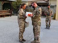 Medal Parade Eine Soldatin bekommt Geschenke überreicht.