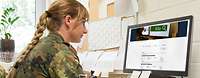 Kita Suche Eine Soldatin bei einer Internetrecherche an einem Computer
