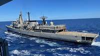 Ein Schiff wird auf hoher See von einem anderen Schiff über Schläuche betankt