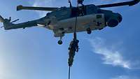 Ein Soldat seilt sich aus einem Hubschrauber ab