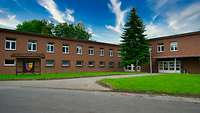 Ein Backsteingebäude, davor das Wappen des Regimentes
