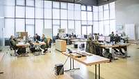 Ein Saal mit Glasfassade, in dem viele Computerarbeitsplätze stehen