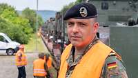 Ein Soldat mit orangefarbener Warnweste schaut in die Kamera.