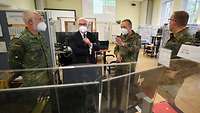 Bundespräsident Steinmeier im Gespräch mit Soldaten in einem Raum mit Computern und Stellwänden