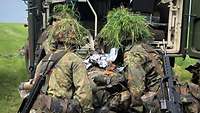 Vier Soldaten verladen eine Krankentrage in ein Krankenfahrzeug.
