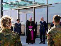 Antreten zum Segen Vier Soldatinnen und Soldaten stehen vor dem Bischof und hören ihm zu.