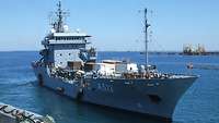 A grey ship in port.