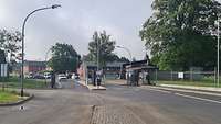 Die Wache Zwei Fahrspuren führen auf zwei Schranken und Wachhäuser zu.