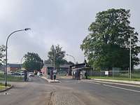 Zwei Fahrspuren führen auf zwei Schranken und Wachhäuser zu.