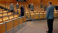 Mehrere Soldatinnen und Soldaten in einem großen Saal verteilt