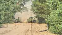 Durch eine Optik mit Fadenkreuz sind zwei getarnte Schützenpanzer Marder zu erkennen. 