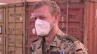 Ein Soldat vor einem Geländefahrzeug in einem Feldlager in Afrika