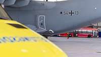Im Hintergrund steht ein Transportflugzeug, während im Vordergrund ein Rettungsfahrzeug wartet