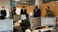 5 Männer stehen in einem Büro zusammen und unterhalten sich