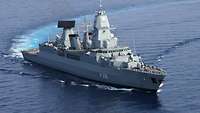 A grey ship is underway on a body of water.