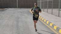 Ein Soldat joggt auf einer Straße im Camp