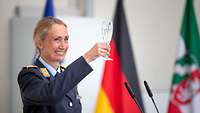 Eine Soldatin hält ein Glas mit Sekt hoch