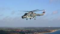 A gray helicopter in flight.