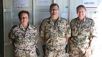 Zwei Soldatinnen und ein Soldat stehen vor einem Bürocontainer