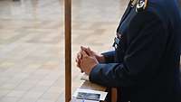Soldat in Uniform faltet die Hände zum Gebet 