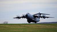 Ein Flugzeug vom Typ A400M fliegt kurz nach dem Start über der Startbahn.