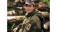 Anja Boldt sitzt in Flecktarnuniform auf Baumstämmen, wärend der Mittagsverpflegung.