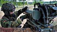 Ein Soldat lädt eine Waffe zur Panzervernichtung mit einem großen Geschoss 