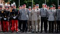 Deutsche und französische Soldaten stehen im Dienstanzug auf einem Appellplatz. 