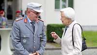 Ein General und eine ältere Dame im Gespräch