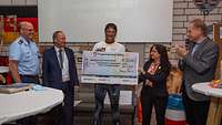 Oberst Johannes Stamm übergibt den Spendenscheck an das Bundeswehr-Sozialwerk.