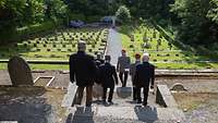 Eine Gruppe von Soldaten steigt die Steinstufen zum Soldatenfriedhof hinunter.. 