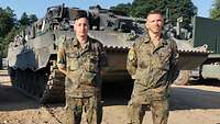 Zwei Soldaten stehen vor einem Panzer 