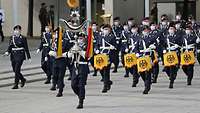 Soldaten des Musikkorps musizieren und marschieren in Formation