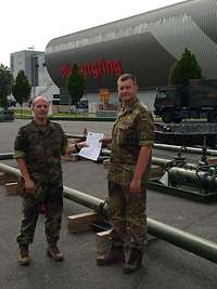 Übergabe der Prüfbescheinigung am Nürburgring Zwei Soldaten halten ein Dokument zwischen sich, im Hintergrund Tankanlagen vor der Außenwand einer Tribüne