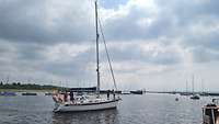Ein Segelboot verlässt einen Hafen.