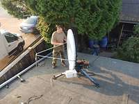 Ein Soldat steht auf einem Dach und justiert eine Satellitenschüssel