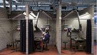 A soldier is welding in a booth.