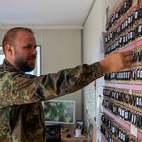 Ein Soldat steht vor einem Schlüsselbrett mit sehr vielen Schlüsseln.