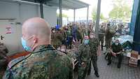 Soldaten haben ein Lager mit Zelten, Fahrzeugen und einer Antenne aufgebaut.