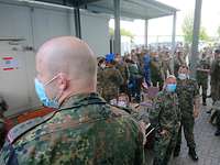 Soldaten haben ein Lager mit Zelten, Fahrzeugen und einer Antenne aufgebaut.