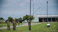 Soldaten bauen im Freien Antennen auf.